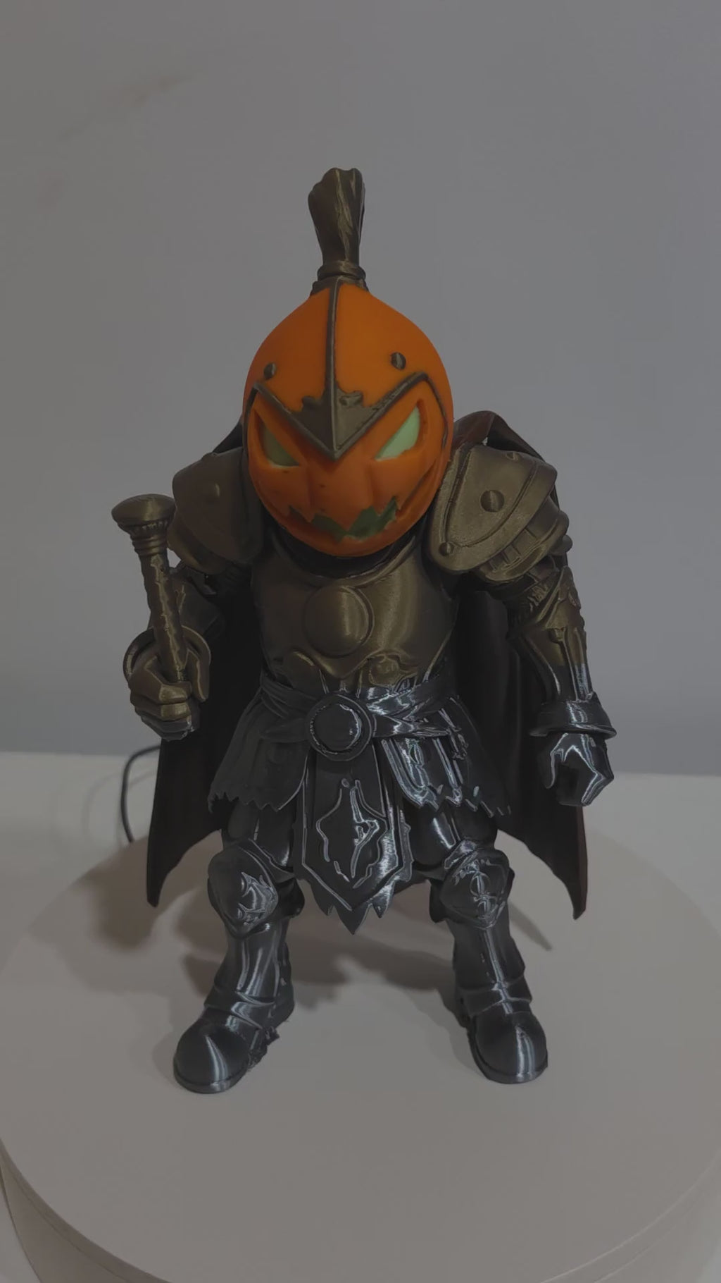 Actual Pumpkin Knight 3D print rotating to show bronze-toned accents, orange pumpkin head and brown cape.